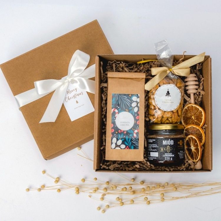 Brązowe kwadratowe pudełko kraft ze wstążką z miodem z cynamonem, herbatą zimową i orzeszkami