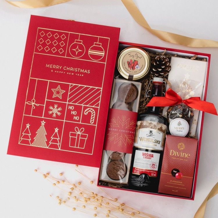 Świąteczne czerwone pudełko z szyszką, wstążką, butelką Wiśnia z Brandy, salsą i czekoladami