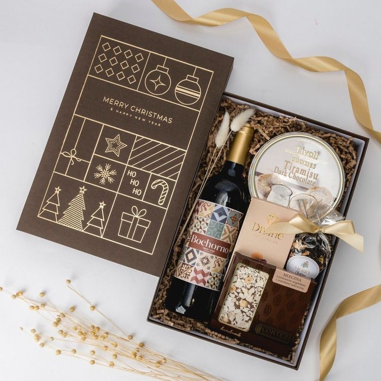 Świąteczne brązowe pudełko z czerwonym winem, puszką ciastek, mleczną czekoladą i herbatą