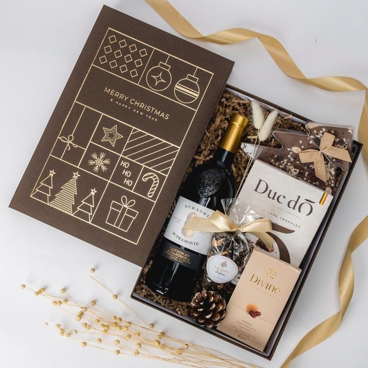 Świąteczny zestaw w brązowym pudełku z czerwonym winem pralinami czekoladą choinką i herbatą