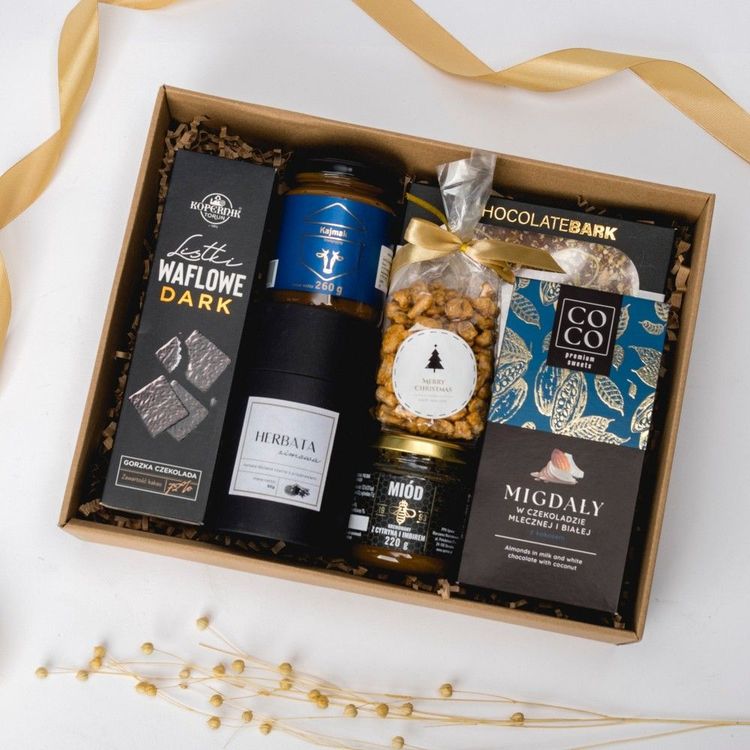Świąteczny zestaw w brązowym pudełku kraft z czekoladami słoikami miodu kajmaku i herbatą