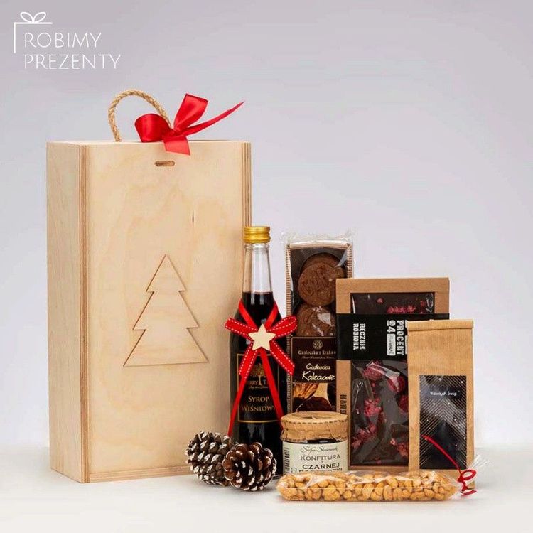 Drewniana skrzynka świąteczna z wyciętą choinką, syropem wiśniowym, konfiturą porzeczkową i czekoladą