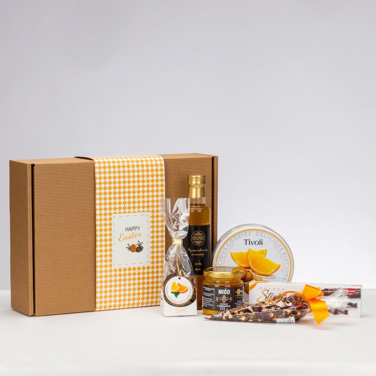 Brązowe pudełko kraft przewiązane żółto-białym pasem w kratkę z syropem imbirowym miodem i słodyczami