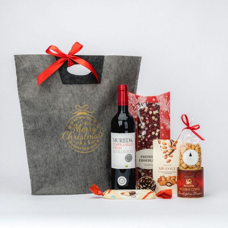 Szara torba filcowa świąteczna z butelką czerwonego wina, czekoladą i migdałami