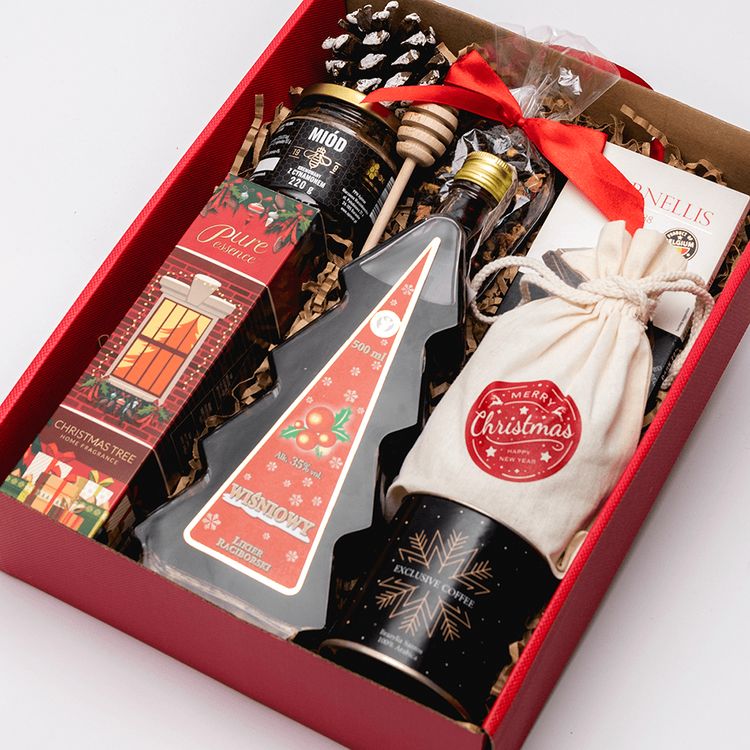 Świąteczne czerwone pudełko z miodem z cynamonem, butelką wiśniową, kawą i ciastkami owsianymi