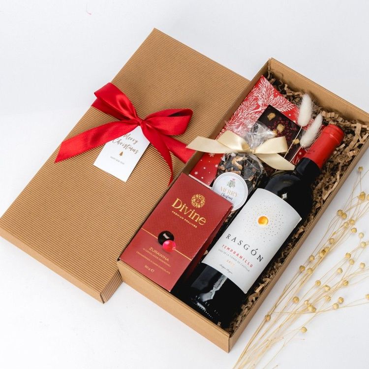 Świąteczne pudełko kraft brązowe z czerwoną wstążką, winem Rasgón, czekoladą Divine Chocolate i herbatą